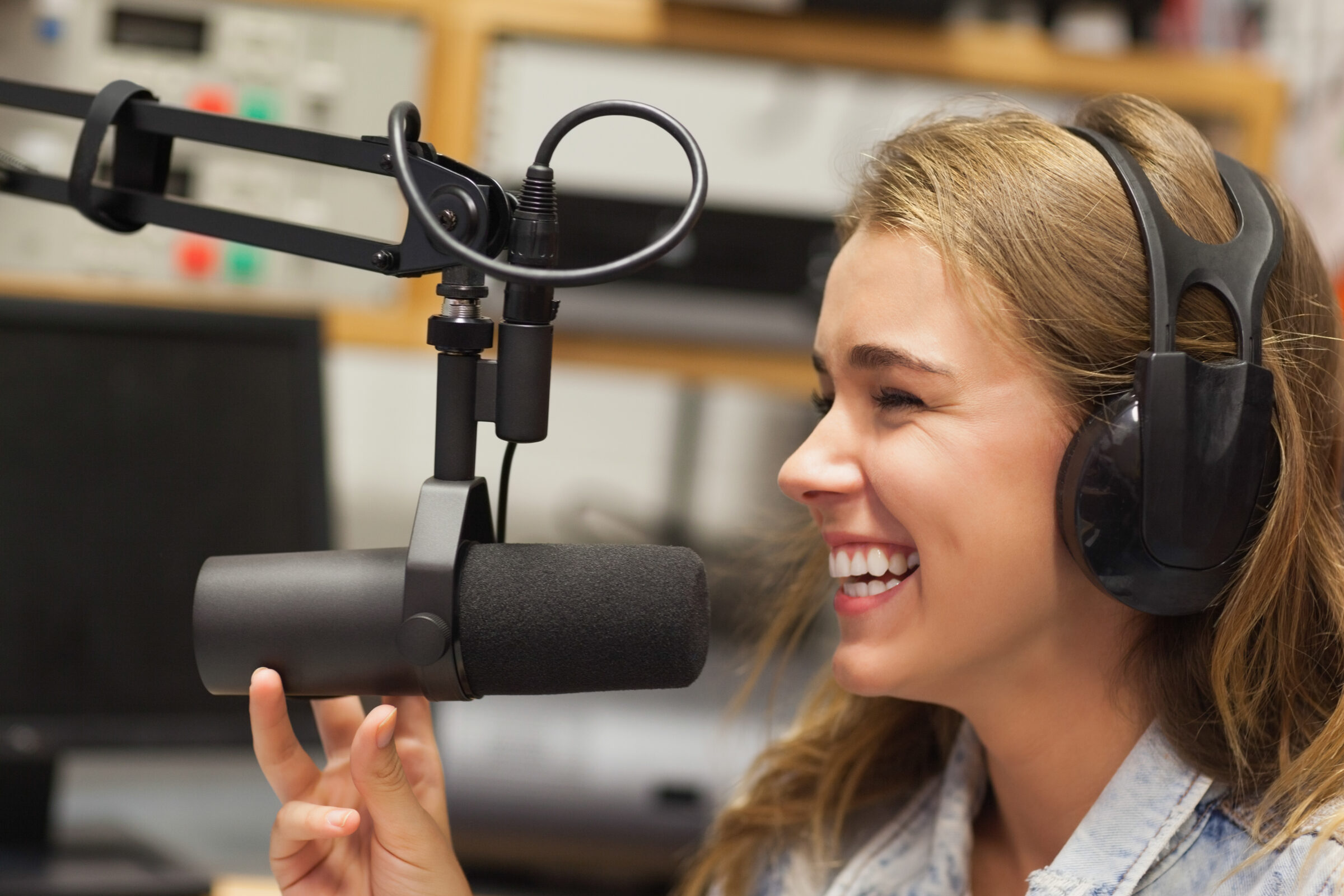 Laughing pretty radio host moderating sitting in studio at college